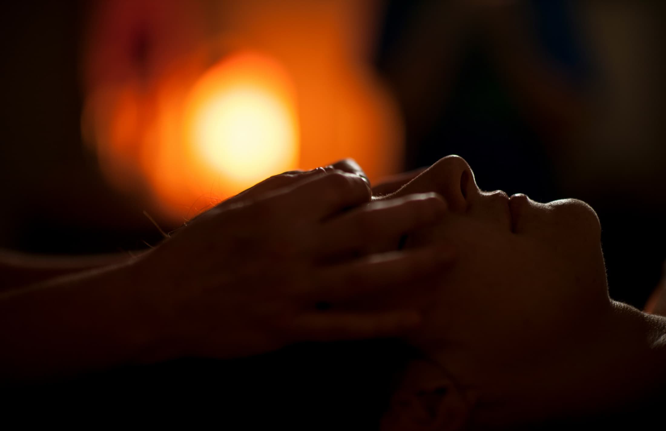 Peters händer i en healingsession, i varmt motljus